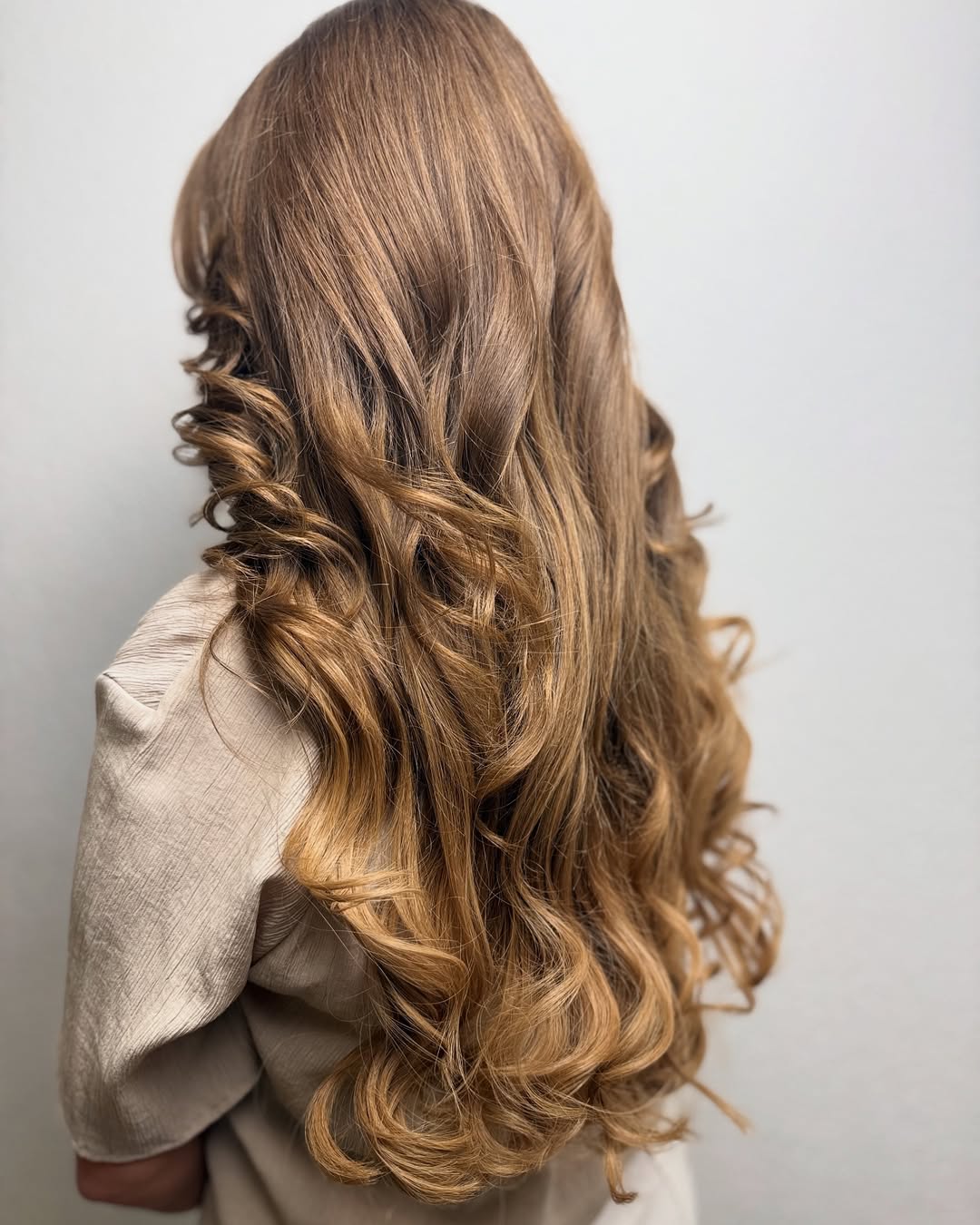 Balayage caramel et longues boucles volumineuses par Shana — Beauty Studio Lutry